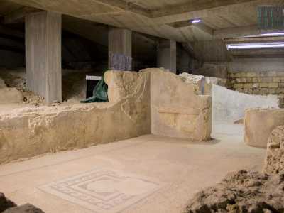 Una passerella in legno guida il turista tra mosaici e intonaci originali...